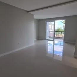 Ambiente interno com paredes brancas e porta de vidro que dá acesso a uma área externa.