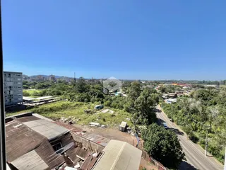 Vista aérea de uma propriedade com vegetação densa e estruturas em primeiro plano.