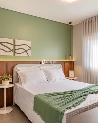 Quarto com cabeceira de madeira e paredes verde-água.