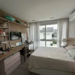 Foto de um quarto com cama e cortinas brancas em um imóvel.