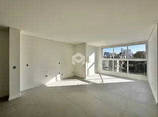 Ambiente interno de uma sala ampla com grande janela.