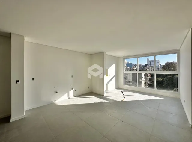 Ambiente interno de uma sala ampla com grande janela.