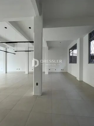 Um corredor amplo com piso de cerâmica claro.