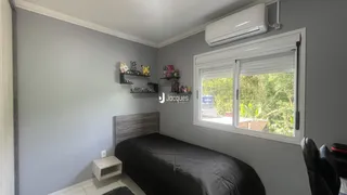 Quarto com cama e janela em ambiente claro.