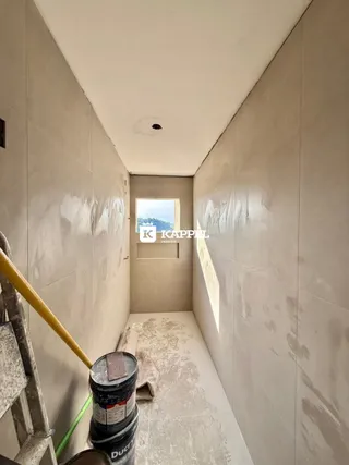 Uma foto de um corredor interno mostrando paredes em construção.