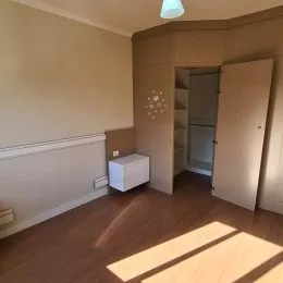 Hall de entrada com piso de madeira e parede clara.