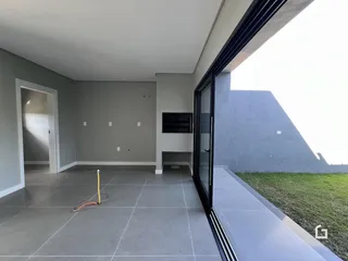 Vista interna de uma área com piso de cerâmica e paredes cinzas.