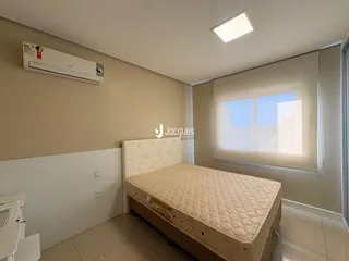 Quarto com cama e ar condicionado instalado na parede.
