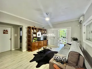 Uma sala de estar com sofá e estante de madeira em um apartamento.