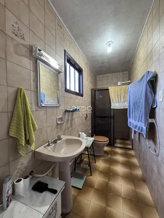 Foto de um banheiro com piso de cerâmica e paredes revestidas.
