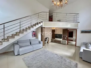 Sala de estar com escadaria e decoração moderna em imóvel no Brasil.