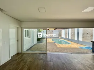 Vista da sala de estar com acesso à área externa e piscina.