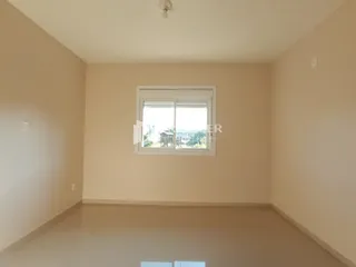 Imagem de uma sala de estar vazia com uma grande janela.