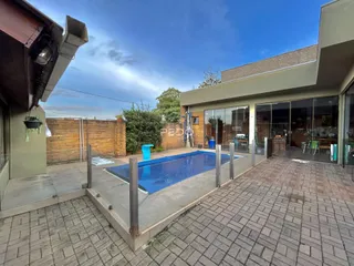 Foto da área externa com piscina e pátio de uma residência em Lajeado.