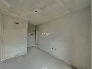 Hall de propriedade com paredes brancas e piso de concreto.