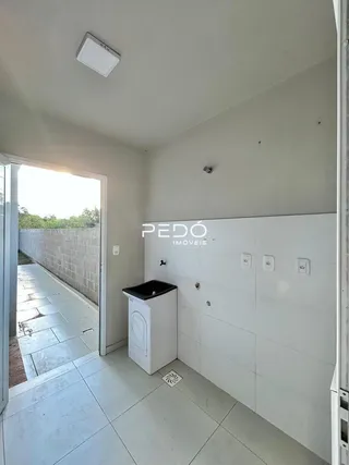 Hall de entrada com piso de cerâmica e passagem para o exterior.