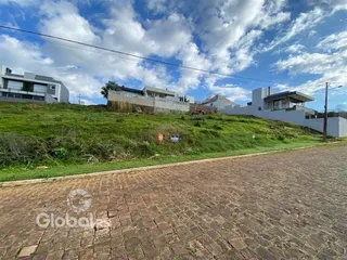 Vista externa de residências em Lajeado, Brasil, com terreno gramado e pavimentação.