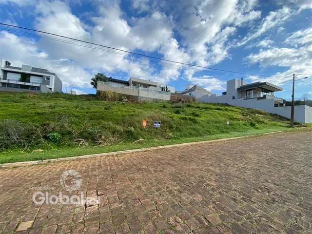 Vista externa de residências em Lajeado, Brasil, com terreno gramado e pavimentação.