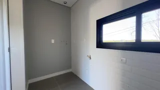 Hall de entrada com paredes brancas e uma janela.