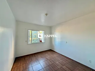 Ambiente interno com piso de madeira e janela em uma sala.