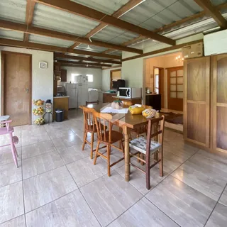 Sala de jantar com piso de cerâmica e vigas de madeira no interior da residência.