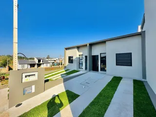 Fachada moderna de uma casa em Lajeado, Brasil, com área externa de concreto e gramado.