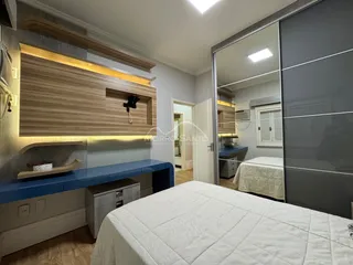 Quarto moderno com cama grande e armários de madeira na sala.