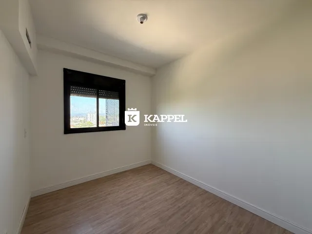Uma sala de estar clara com vista para a paisagem externa.