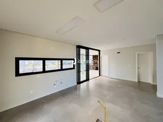 Uma sala de estar com grandes janelas que dão para o exterior.