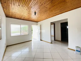 Sala de estar com teto de madeira e piso de cerâmica clara.