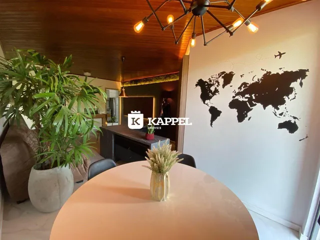 Mesa redonda em um ambiente com teto de madeira e mapa-múndi na parede.