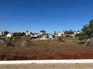 Vista externa de uma área com vegetação seca e edifícios ao fundo em Lajeado.
