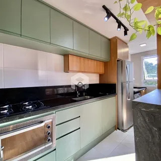 Foto de uma cozinha moderna com armários verdes e bancadas escuras.