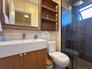 Foto de um banheiro moderno com box de vidro e bancada branca.