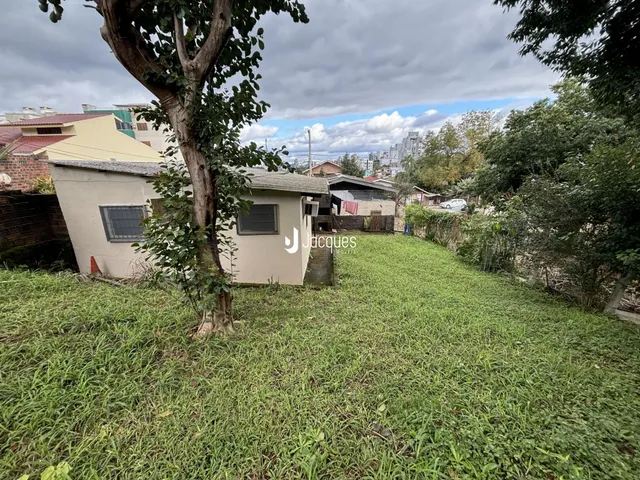 Vista da fachada de uma casa em Lajeado, Brasil, com vegetação densa na frente.