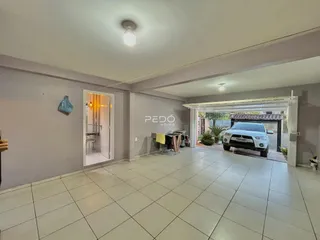 Sala de estar ampla com piso de cerâmica e entrada para área coberta.