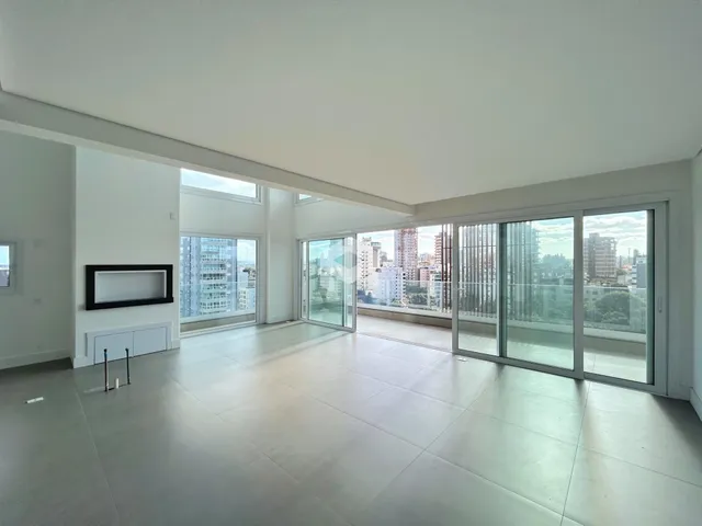 Ambiente interno de uma sala ampla com vista para a cidade.