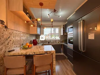 Cozinha moderna com bancada de granito e armários escuros.