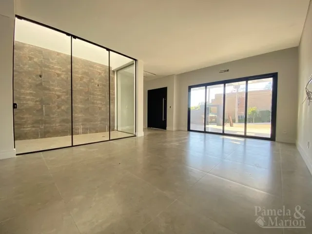Ambiente amplo com piso claro e portas de vidro que dão acesso ao exterior.
