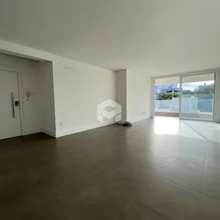 Ambiente interno amplo com piso de cerâmica cinza e portas de vidro.