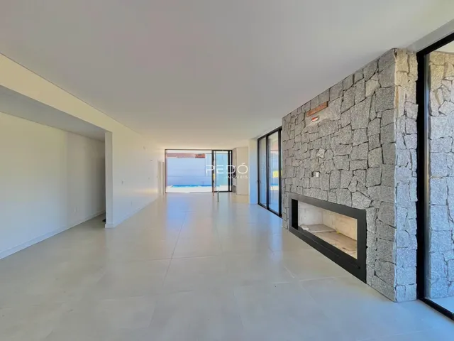 A área interna de uma casa em Lajeado, Brasil, com piso claro e parede de pedra.