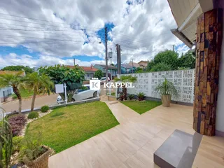 Foto da área externa com gramado e paisagismo de uma residência em Lajeado.