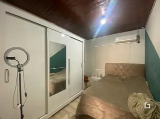 Quarto com armários embutidos e cabeceira de cama.