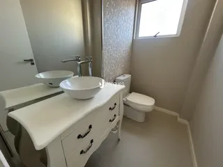 Banheiro moderno com pias duplas e vaso sanitário em um imóvel.