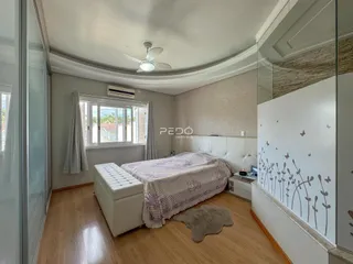 Quarto com cama e janela em ambiente claro.