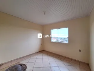 Sala de estar com piso de cerâmica e janela com vista da paisagem urbana.