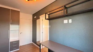 Interior de um quarto com armário embutido e piso de madeira.