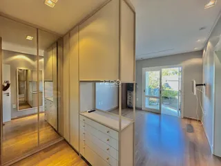 Interior de um ambiente com armários brancos e portas de vidro.