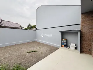 Vista externa da propriedade em Lajeado, Brasil com parede cinza e área de jardim de cascalho.