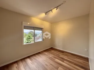 Ambiente interno com piso de madeira e janela de vista para a paisagem.